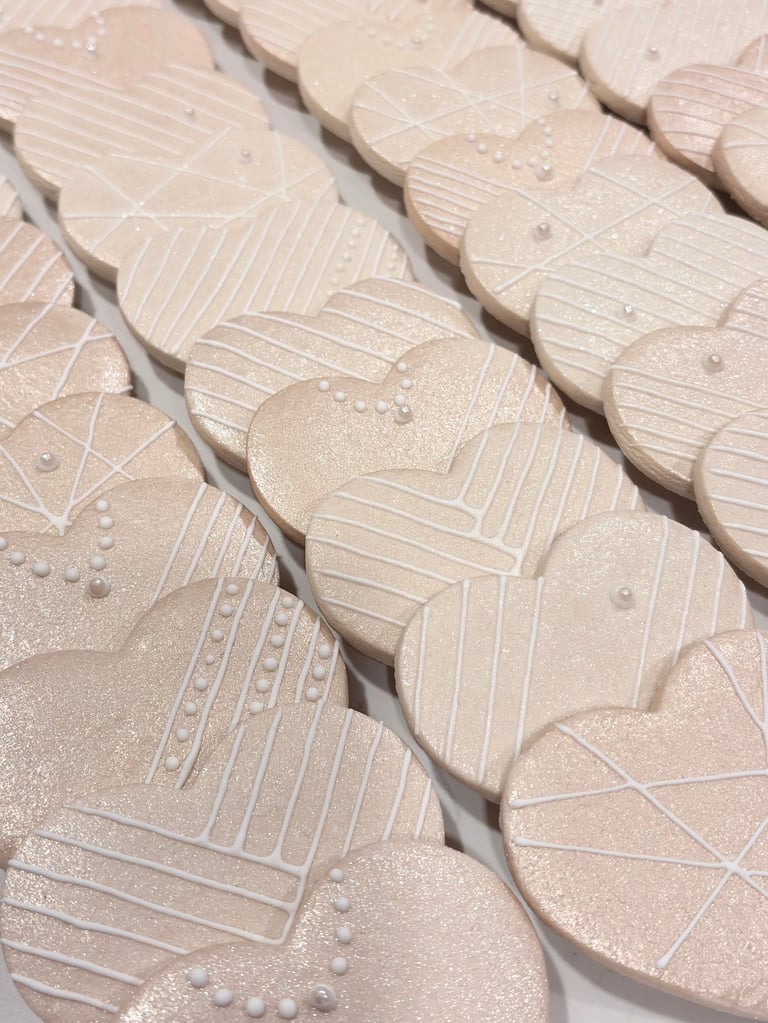 Rows of cream-colored decorative tiles with leaf and geometric patterns, displayed at an angle showing textured surface details.